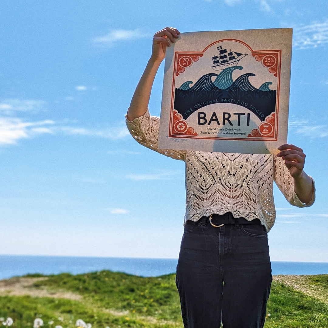 Best Spiced Rum Logo Print held up on a beach