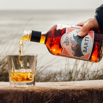 Best Spiced Rum, Barti Spiced being Poured into a glass with ice.